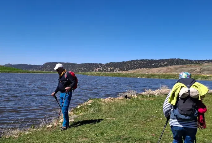 Groupe de randonneurs devant un lac d'altitude dans le Moyen Atlas