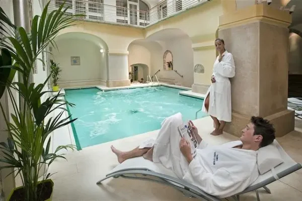 Un couple se relaxe au bord d’une piscine chauffée après une randonnée thalasso au Maroc